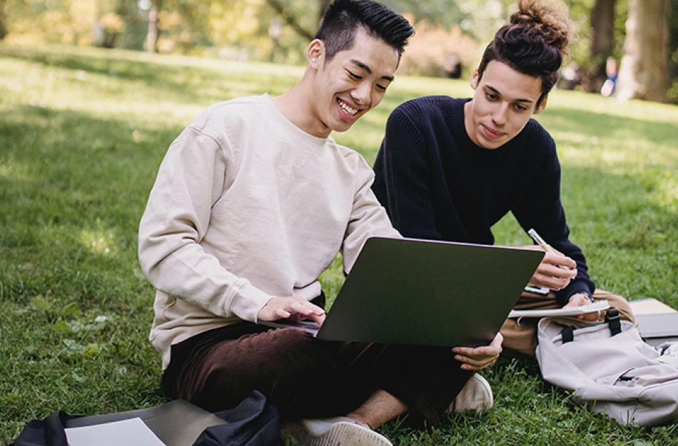 two men looking at a laptop